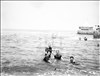 Tre uomini e una donna fanno il bagno in mare ai Bagni Roma