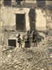Due militari davanti a un edificio distrutto